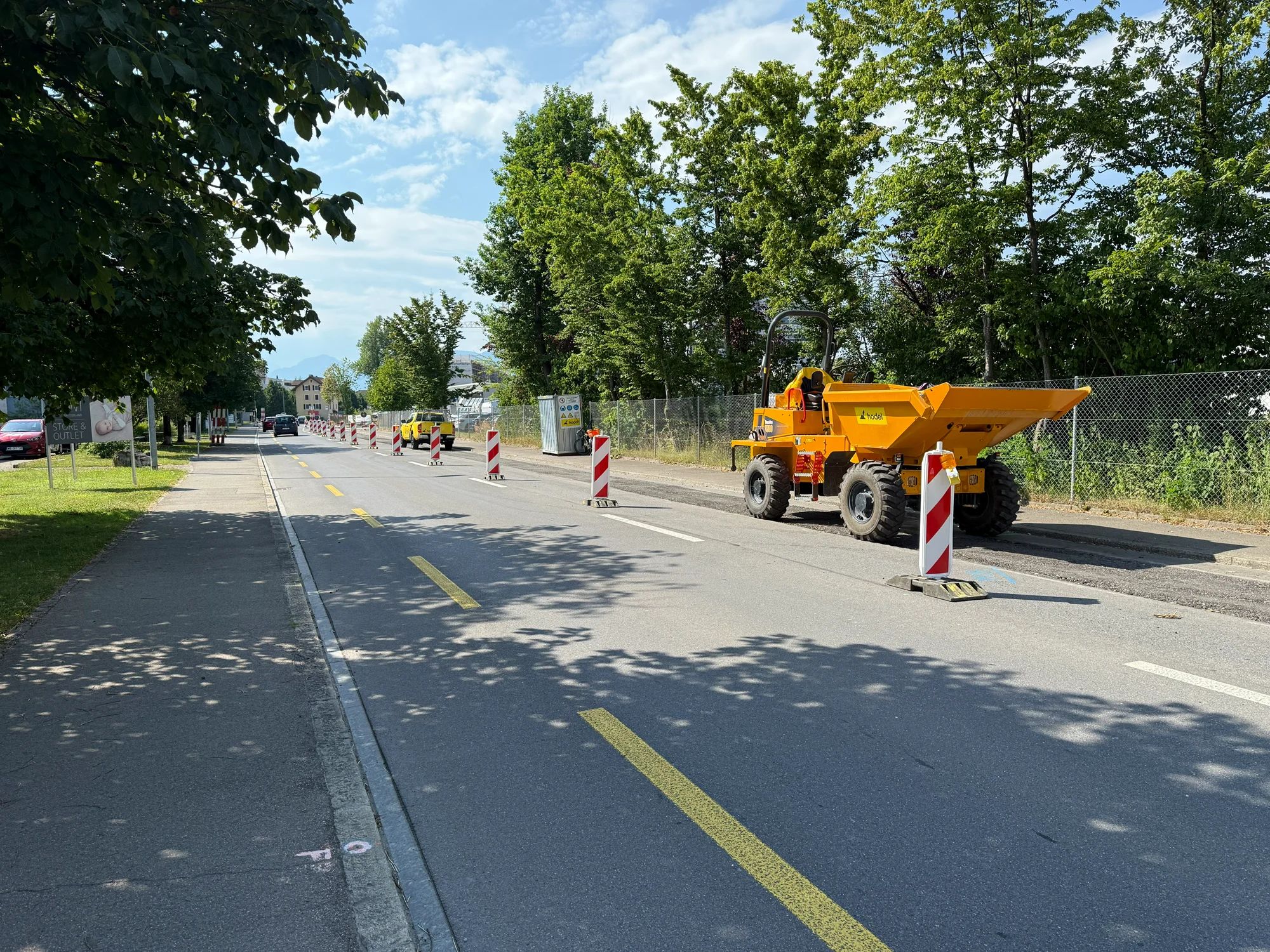 A dumper behind barrier beacons at the edge of the closed lane.